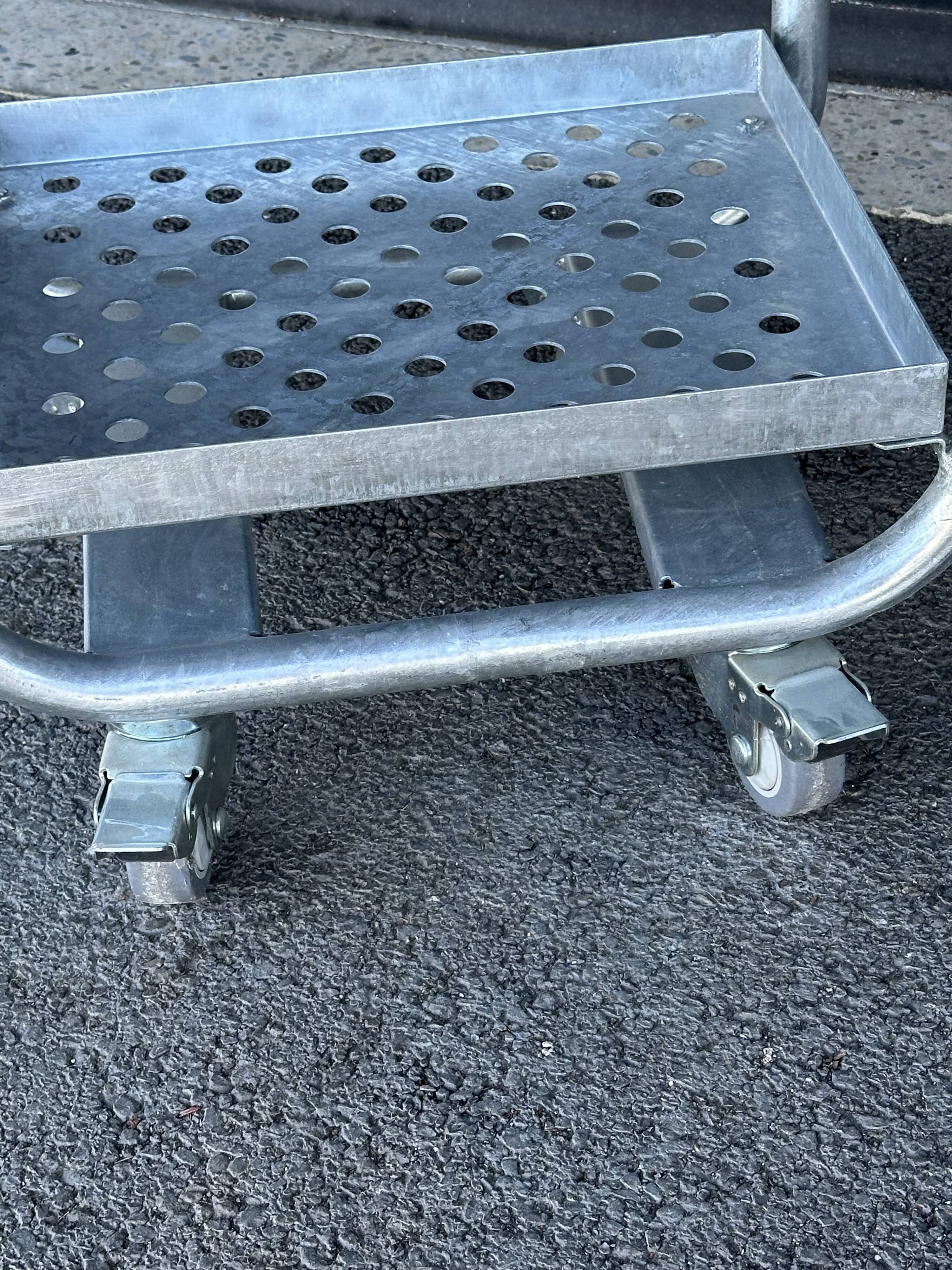 Four-wheeled dessert trolley with 4 perforated metal shelves.
