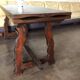 19th-century brown walnut dining table with sculpted trestle legs.