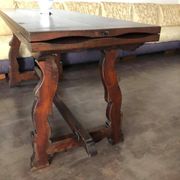 19th-century brown walnut dining table with sculpted trestle legs.