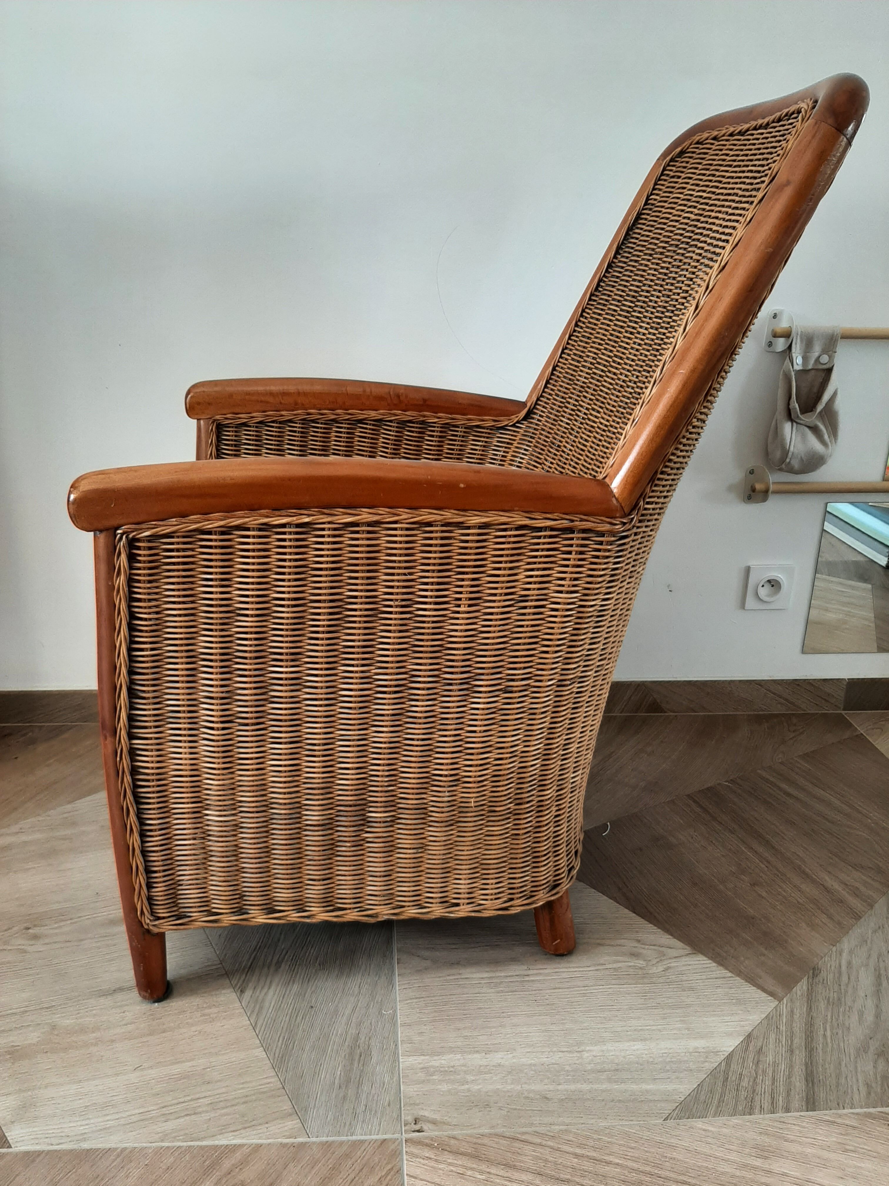 Armchair in woven rattan and exotic wood