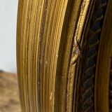 Oval-shaped wooden mirror in gold color