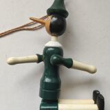 Green pinochio puppet in old wood