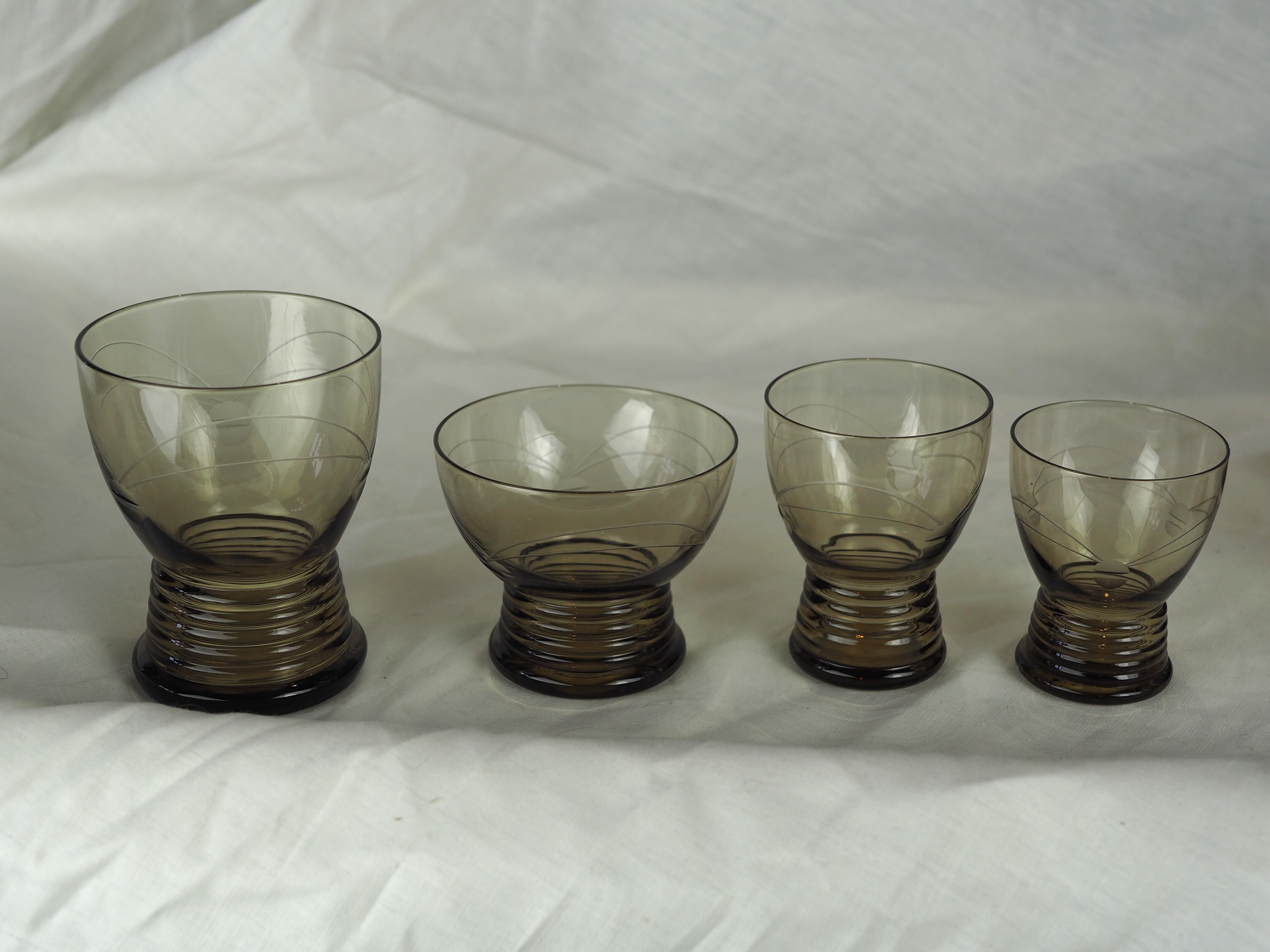 Set of 17 black smoked glasses on geometric engraving stand - 70s