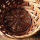 Round woven dark wicker basket with openwork vintage handle