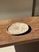 Small oval beige petrified wood dish or tray with speckled edges.