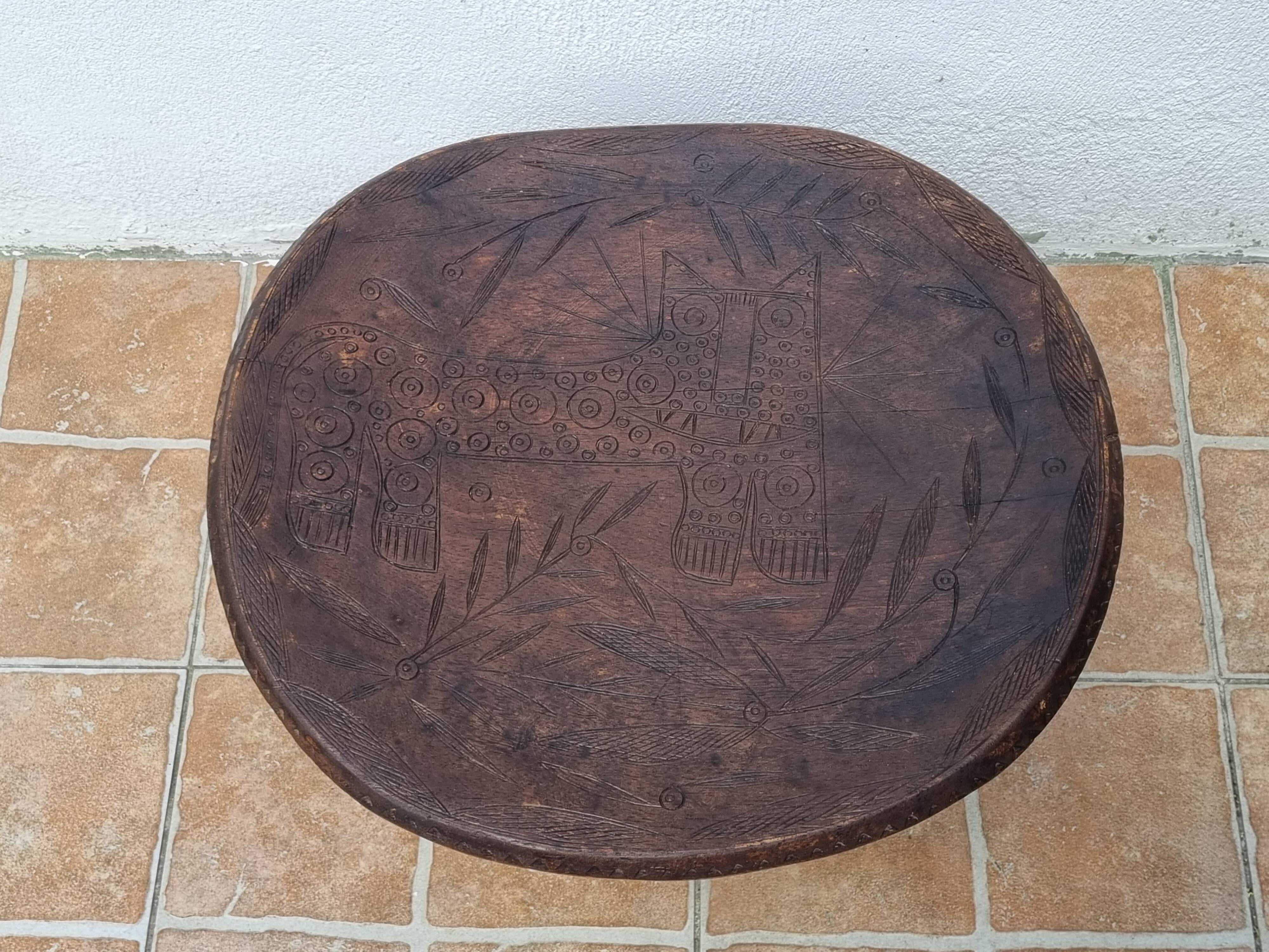 African monoxyle side table in carved wood with a curved top, 48x36 cm.