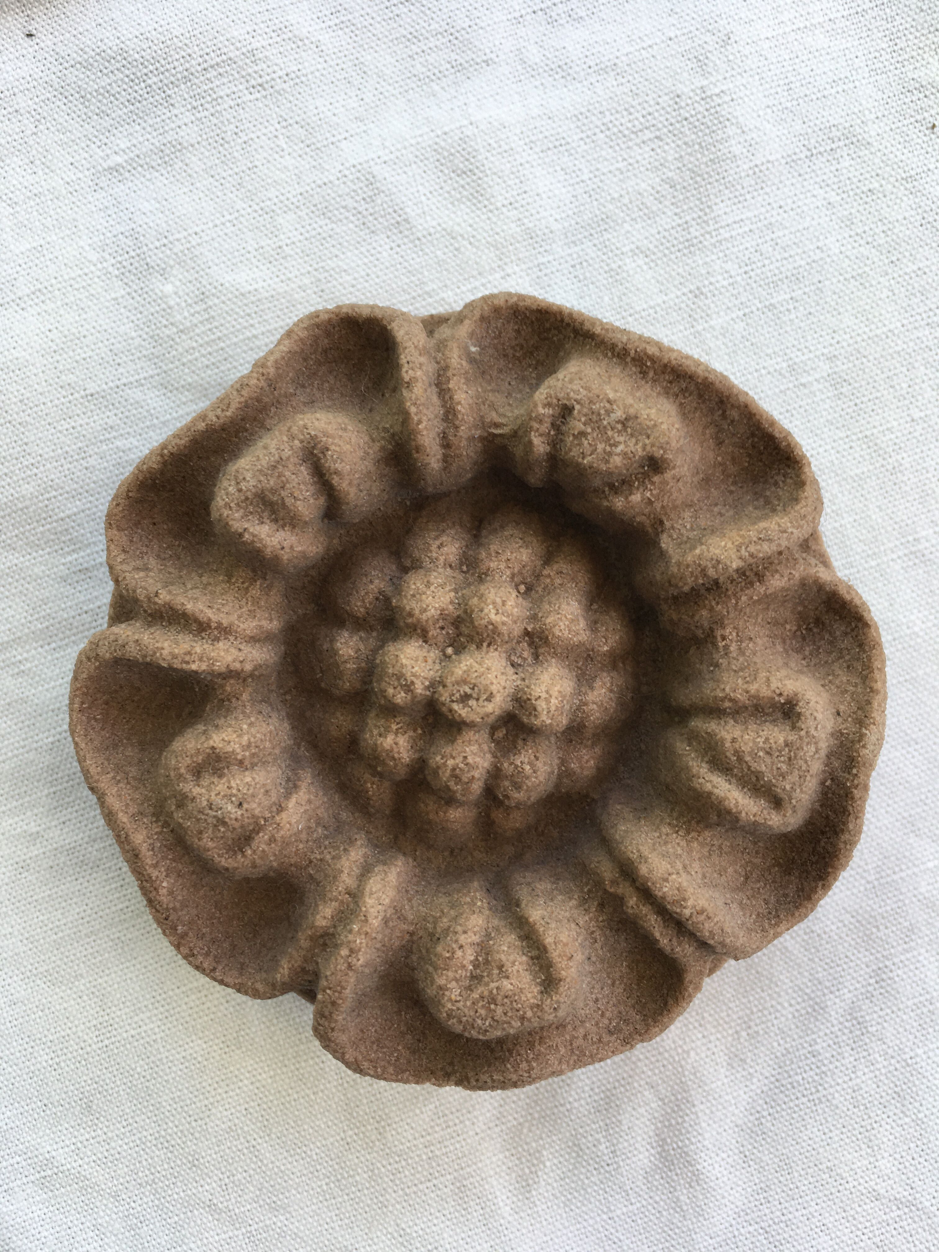 Pink sandstone paperweight in the shape of a rosette