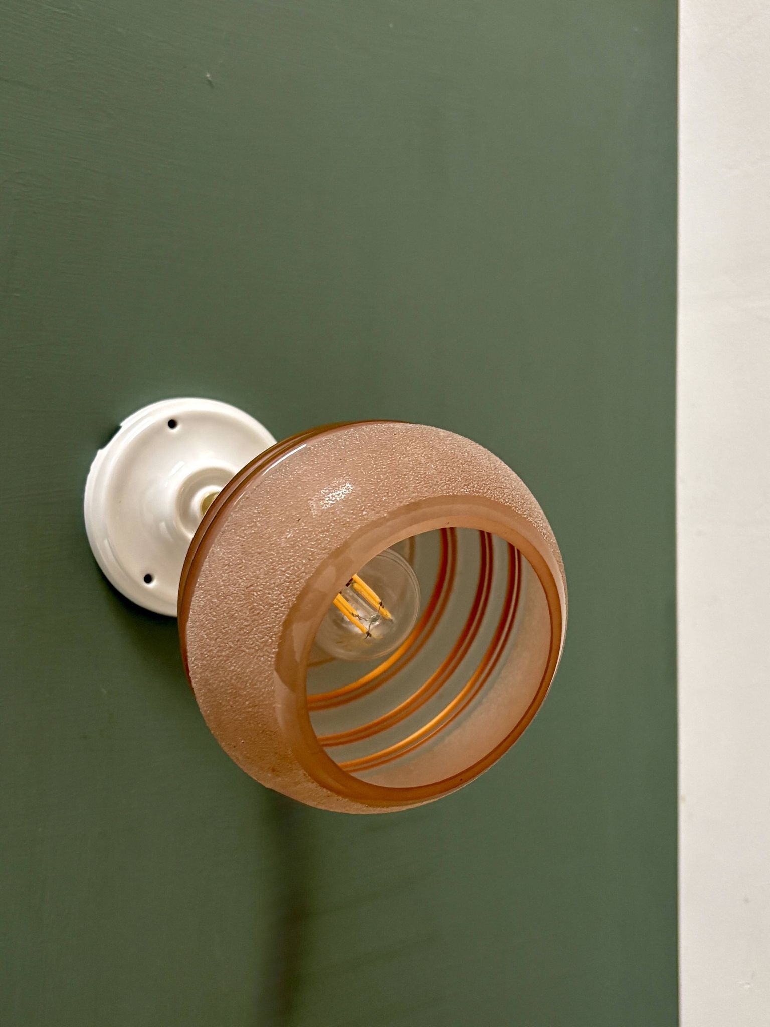 Vintage globe wall light in frosted pink and gold glass.