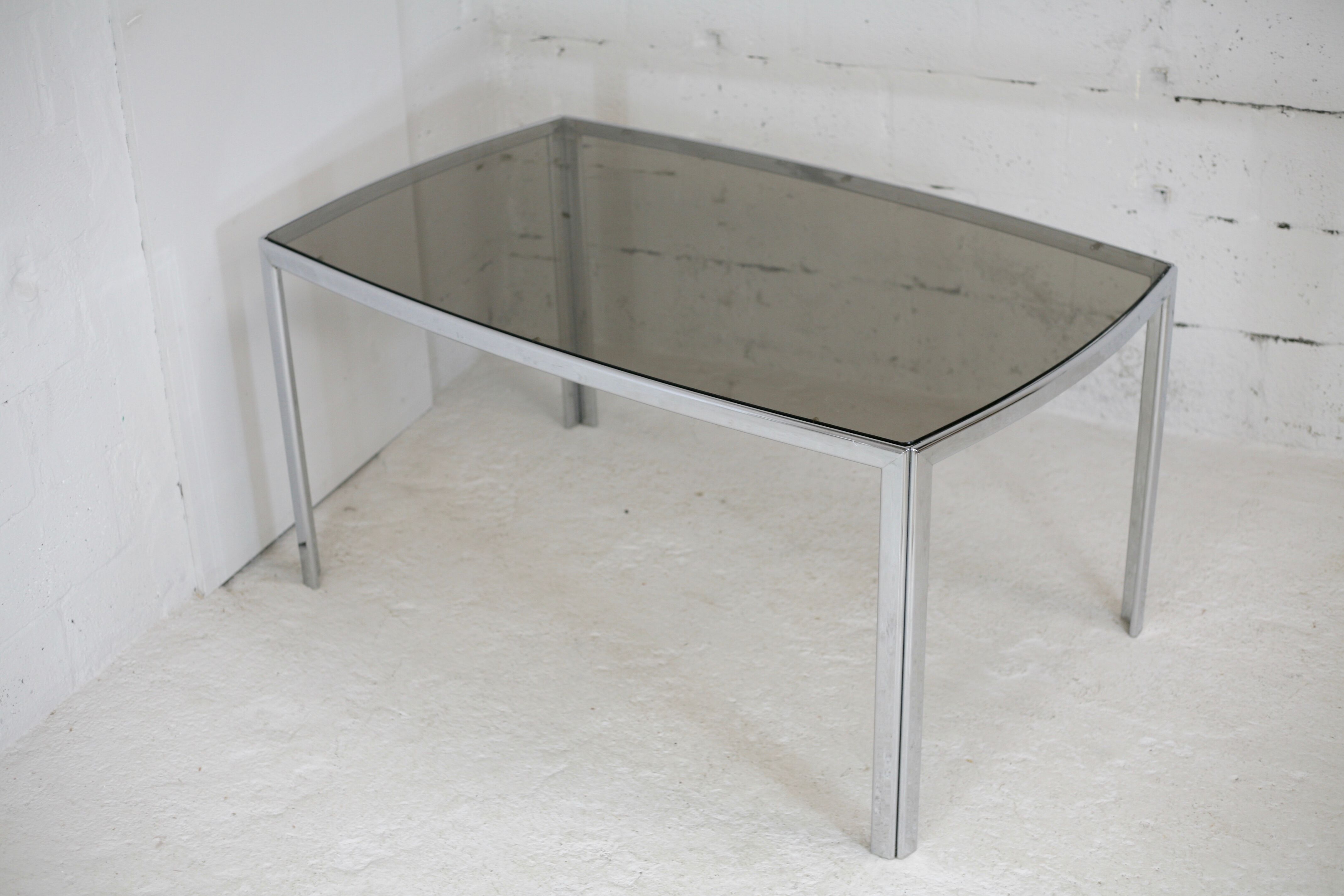 Living table. chrome metal, curved smoked glass slab, france, circa 1970.