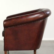 Vintage sheepskin club armchair with decorative nails and black piping