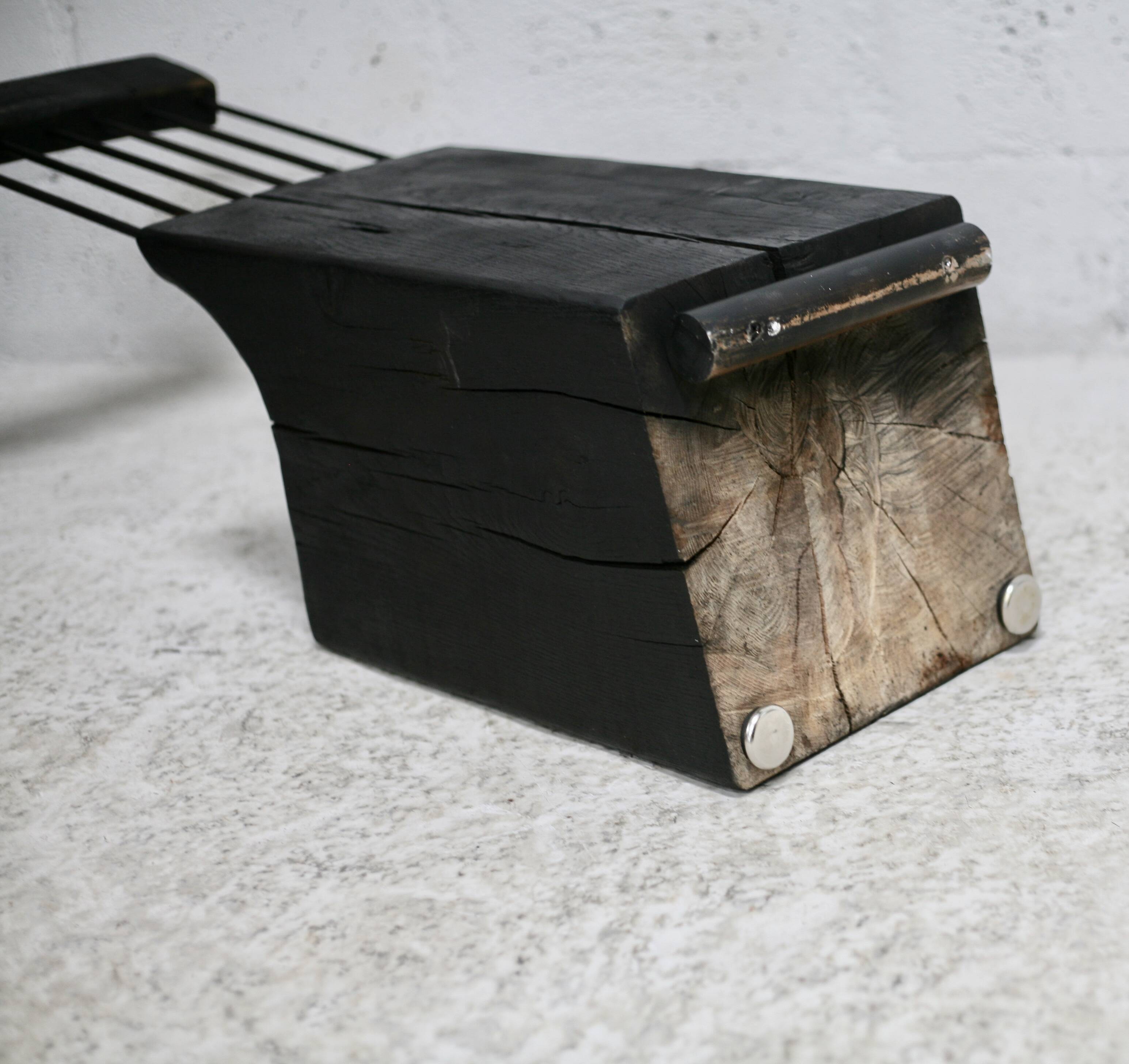 Brutalist chair, black-stained raw wood, steel. Work from the 1970s