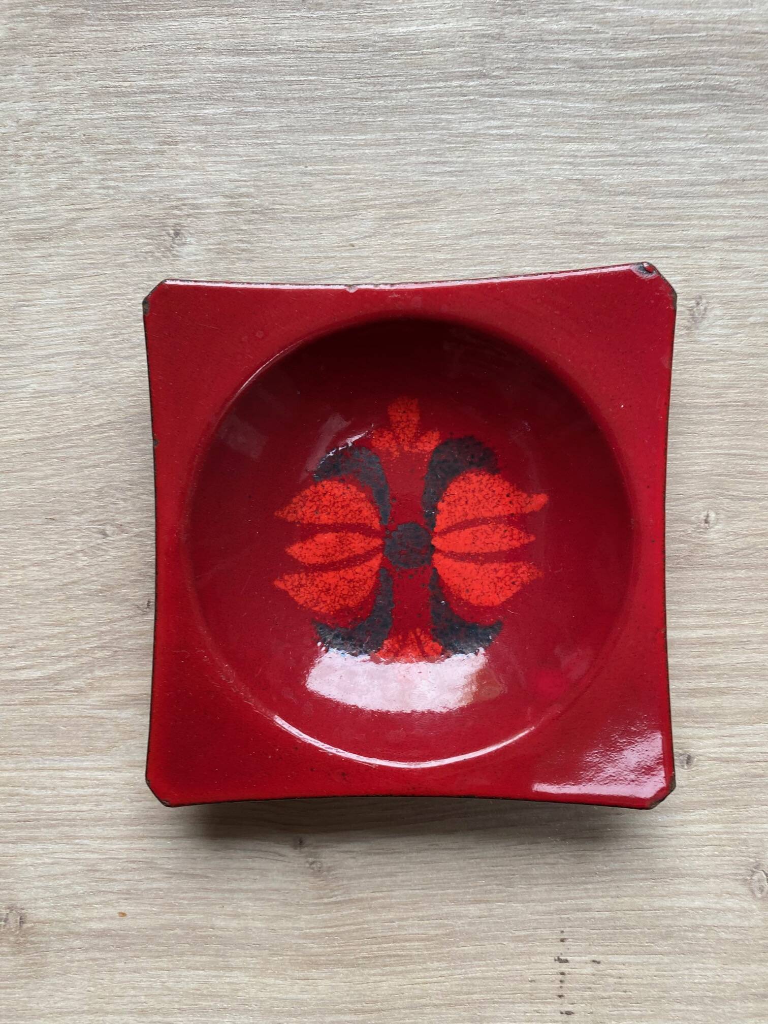 Vintage ashtray in enamelled sheet metal in red tones with floral decor from the 60s