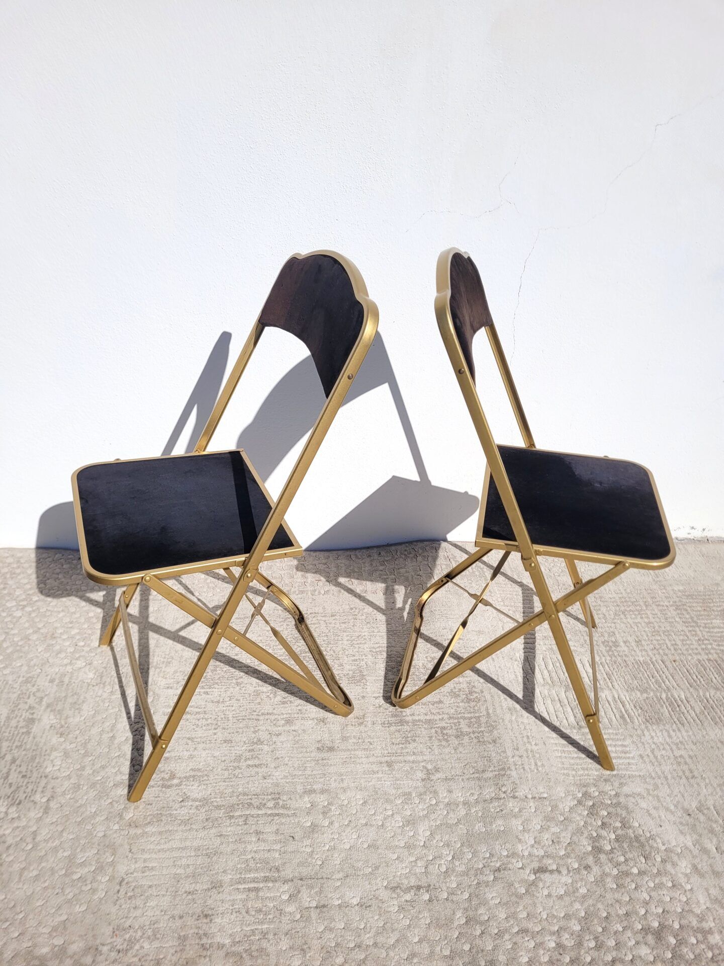 Pair of black and gold folding opera chairs