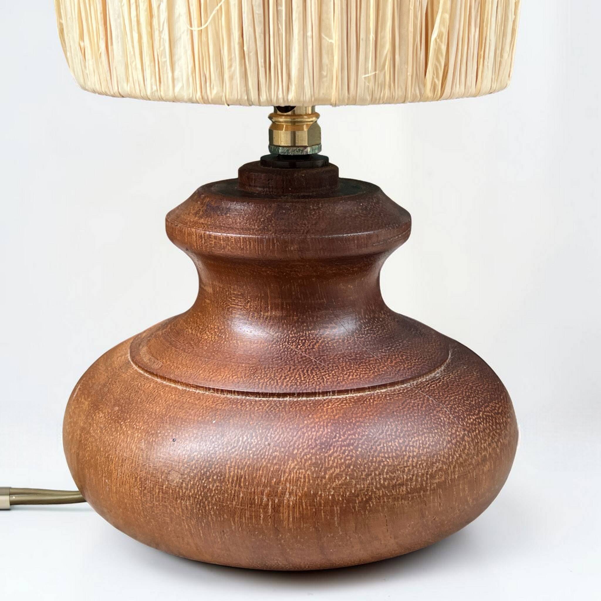Vintage brutalist lamp with a wooden base and a cylindrical raffia shade.