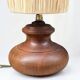 Vintage brutalist lamp with a wooden base and a cylindrical raffia shade.