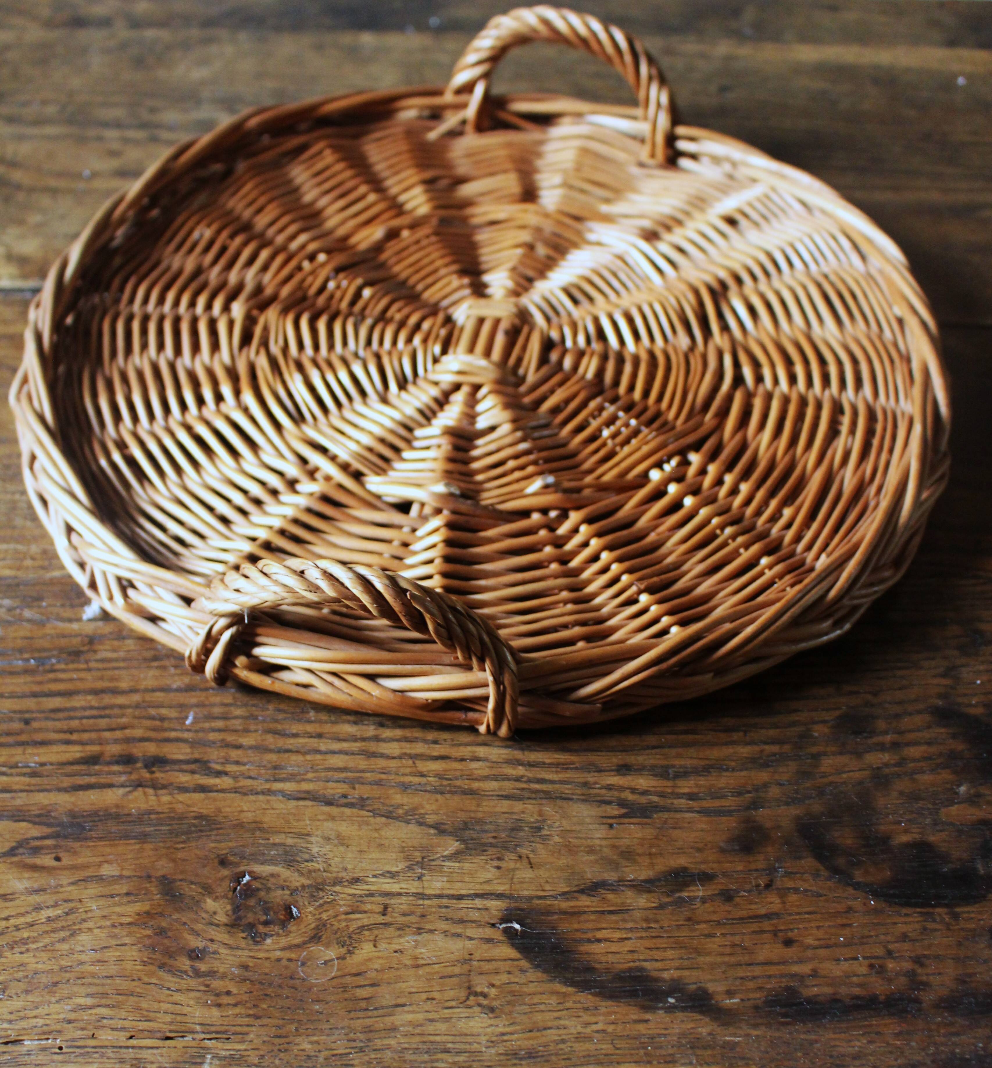 Medium round dark wicker plateau with two handles.