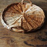 Medium round dark wicker plateau with two handles.