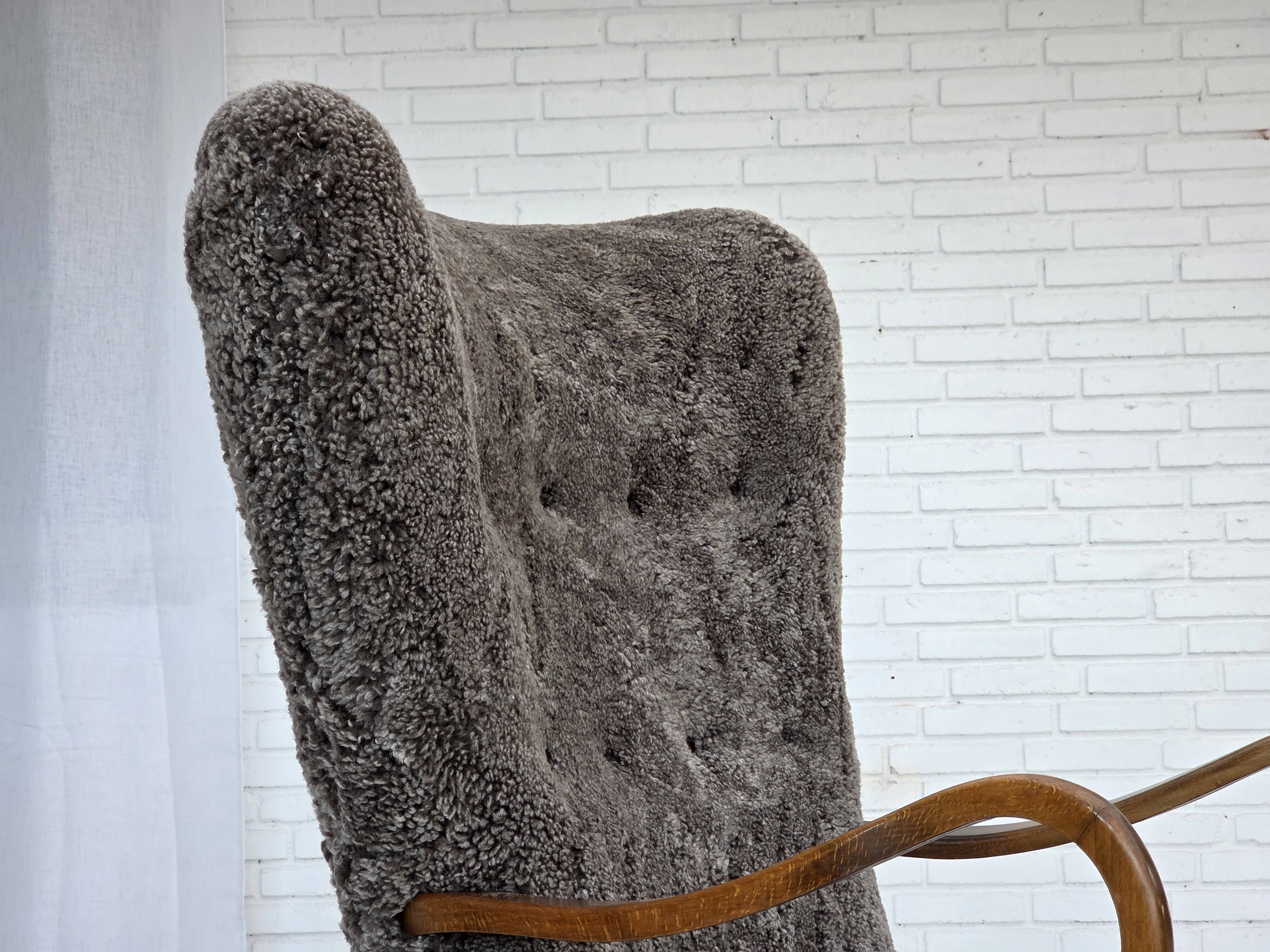 1960s, reupholstered Danish armchair, with stool, genuine sheepskin.