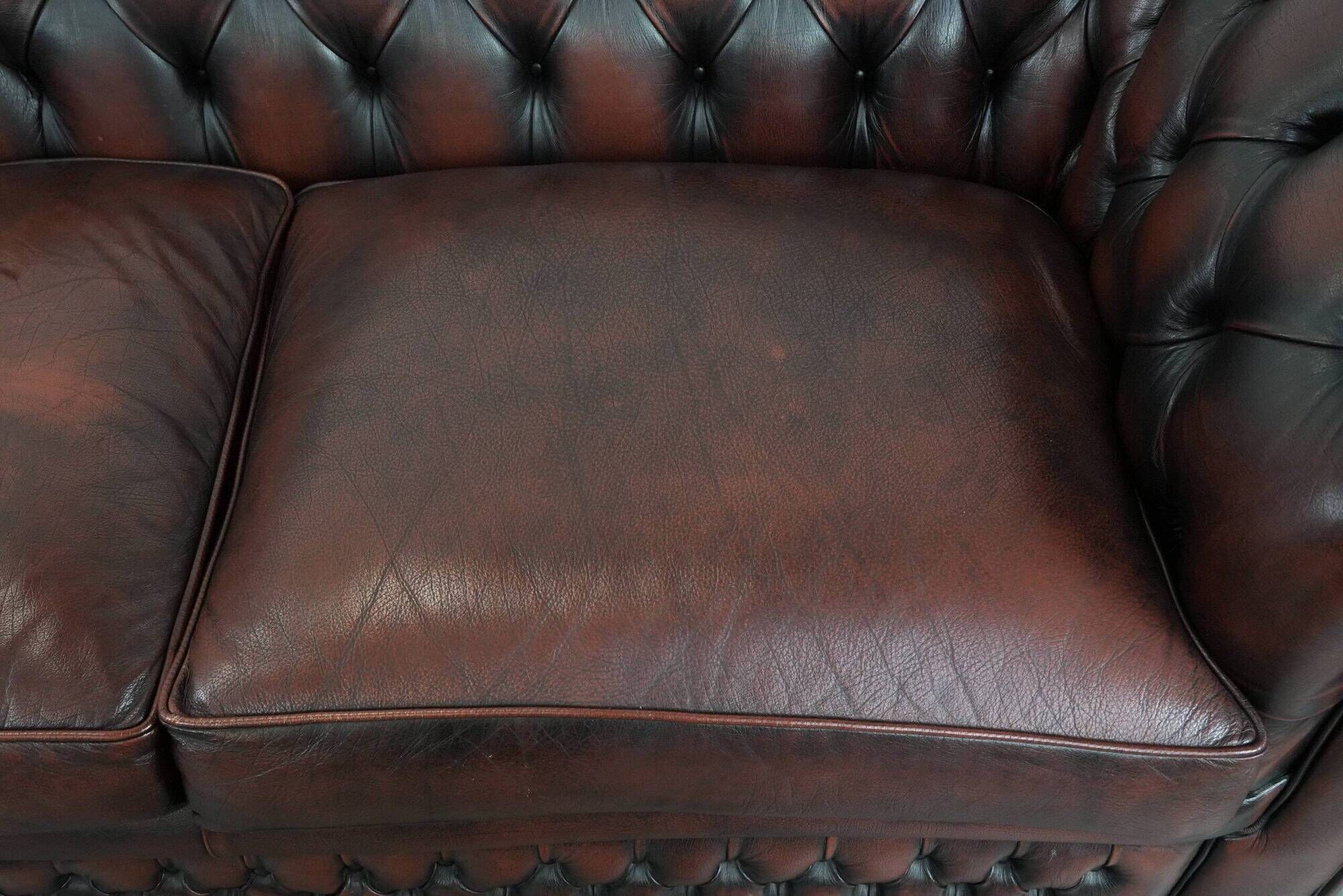 Classic cowhide Chesterfield sofa in English style with red/brown colours
