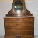 Antique carved wooden dressing table with marble and tilting oval mirror.