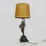 Old table lamp in repel, cherub, angel, cherub, putti with a bird in hand. 1930s