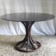 Round dining table tulip foot in rattan and smoked glass 70s