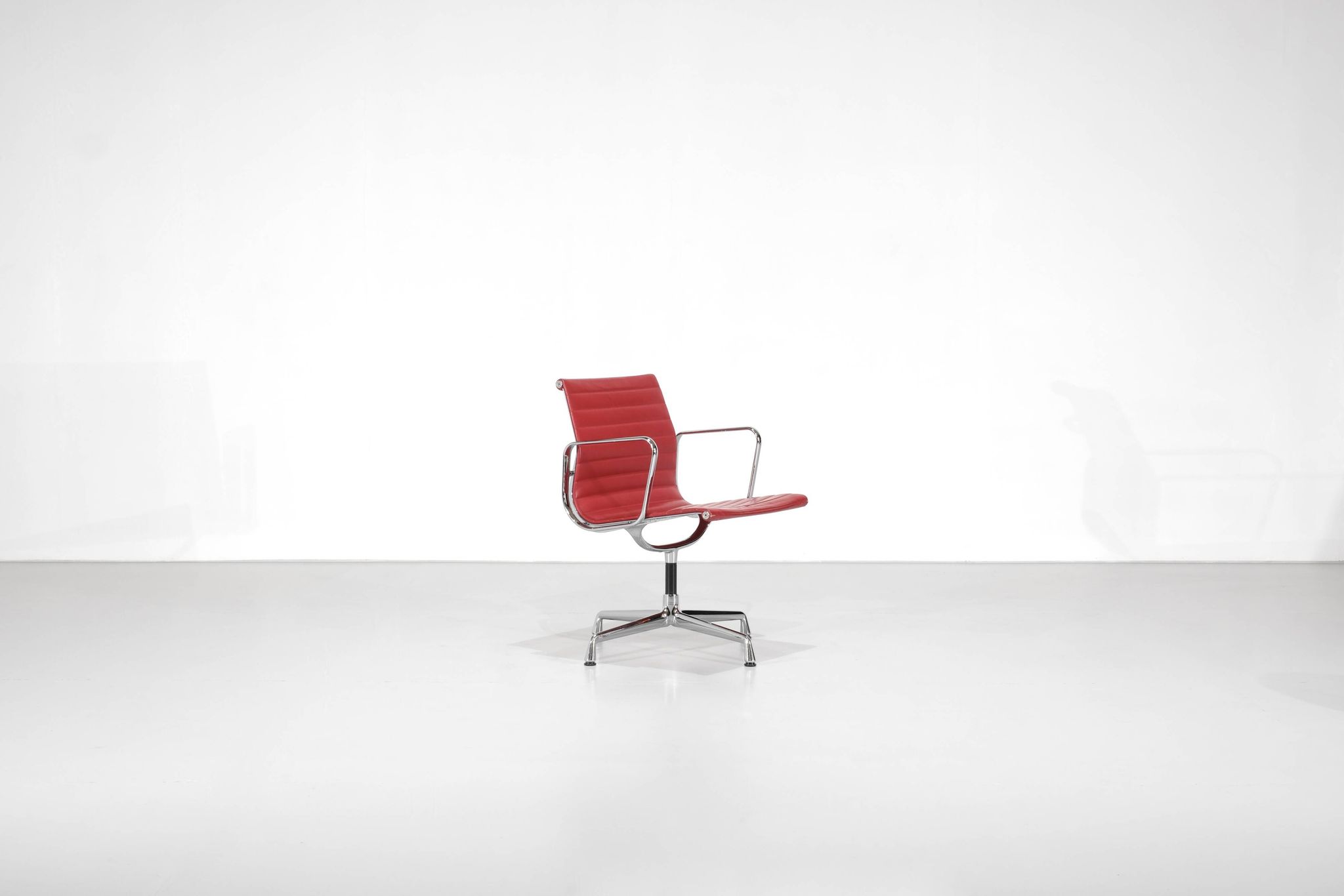 Fauteuil " EA 108 " en cuir rouge, conçu par Charles Ray Eames pour Vitra,