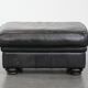 Set of a black cowhide leather Chesterfield armchair and matching ottoman