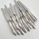 12 antique silver-plated knives with acanthus shell decoration and stainless steel blades.