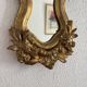 Antique rococo mirror with putti, gilded carved wood and stucco frame, 19th century.