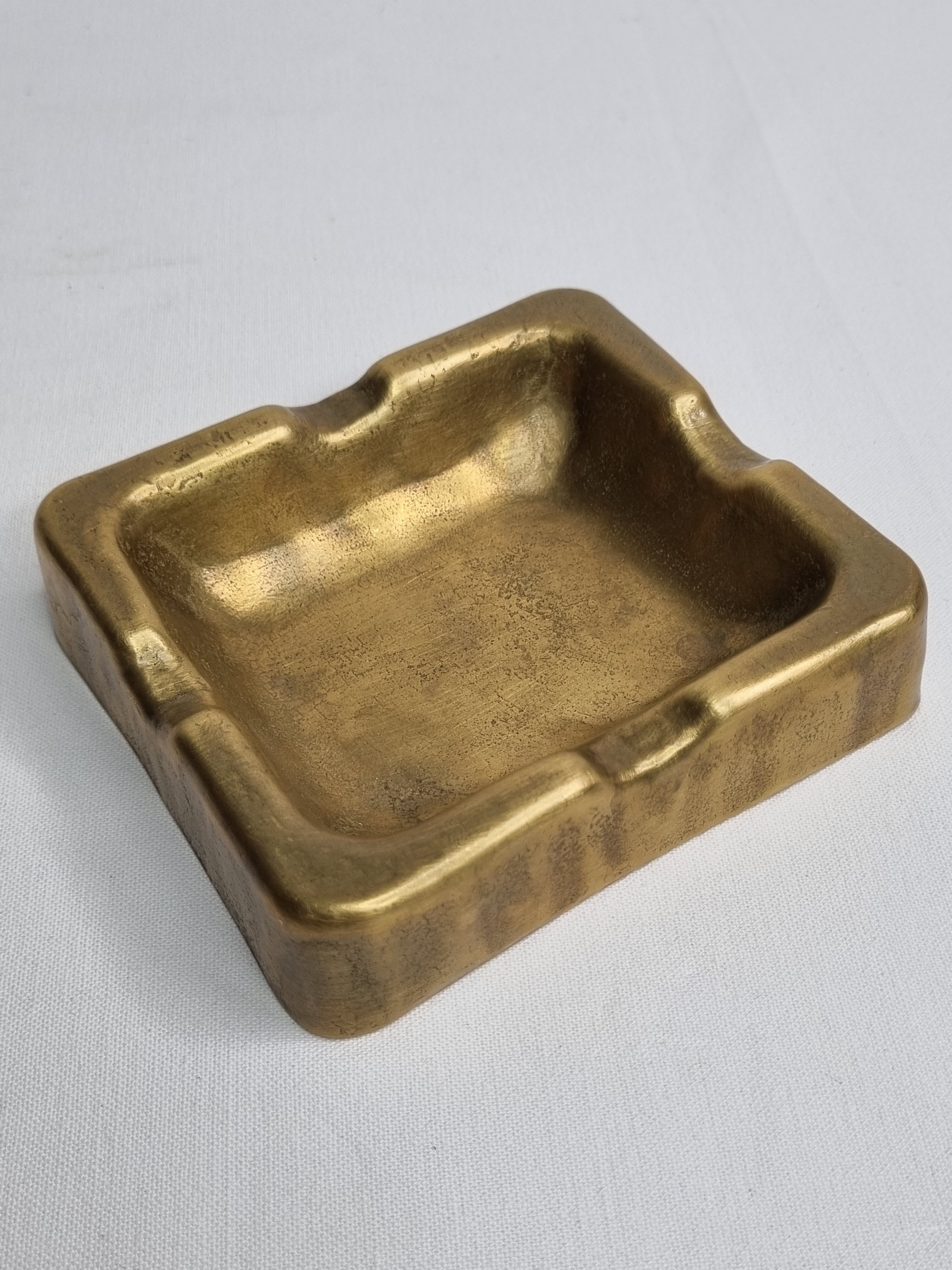 Empty pocket brutalist-inspired ashtray in gilded bronze