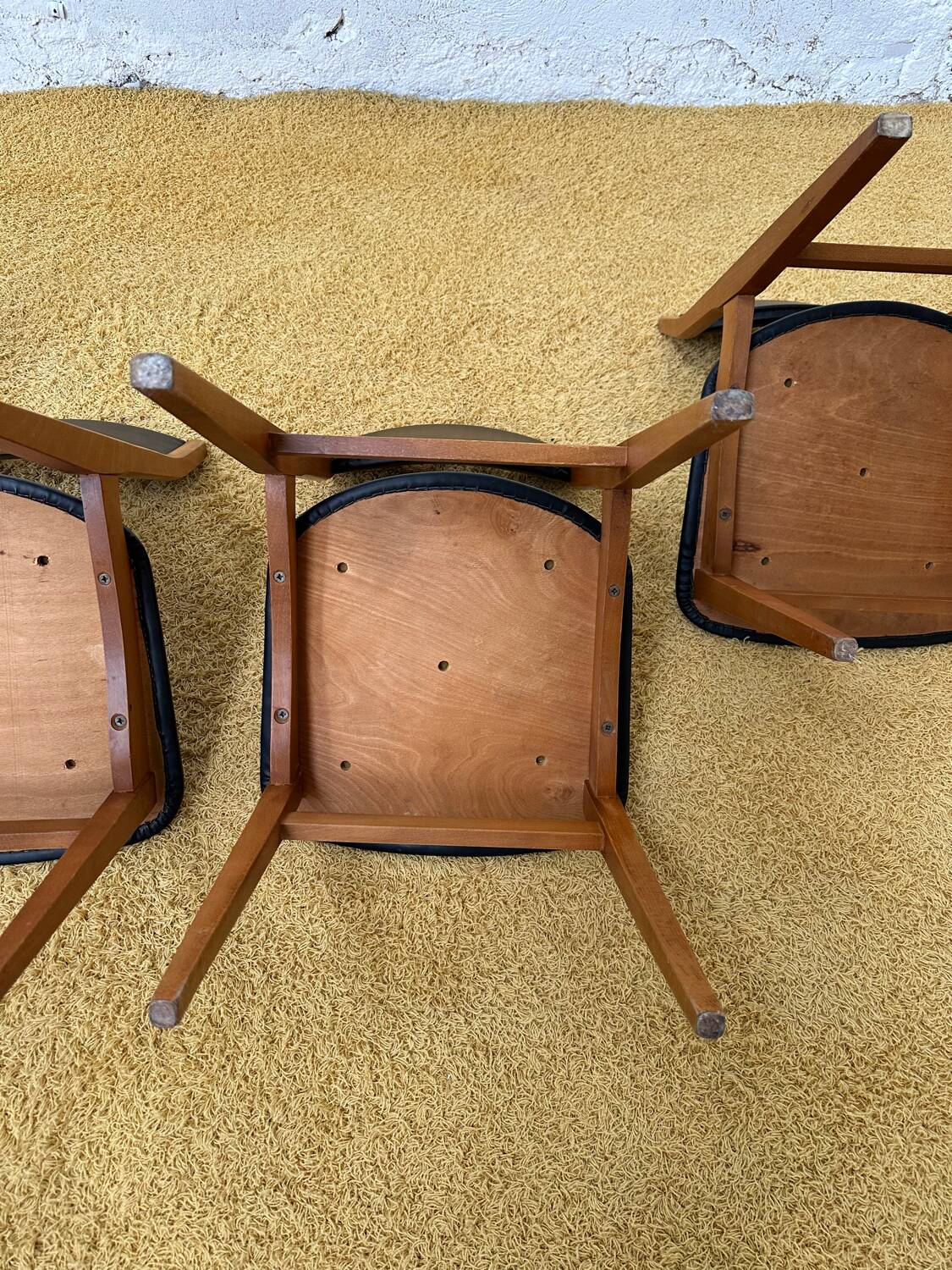 4 Scandinavian chairs in teak and black faux leather.