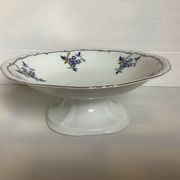 Old shower tray with silver trim and forget-me-not flowers.