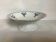 Old shower tray with silver trim and forget-me-not flowers.