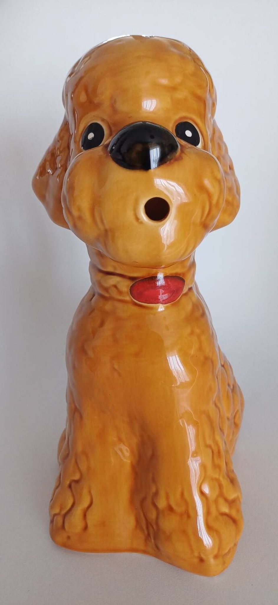 Ancient ceramic pitcher in the shape of a poodle.