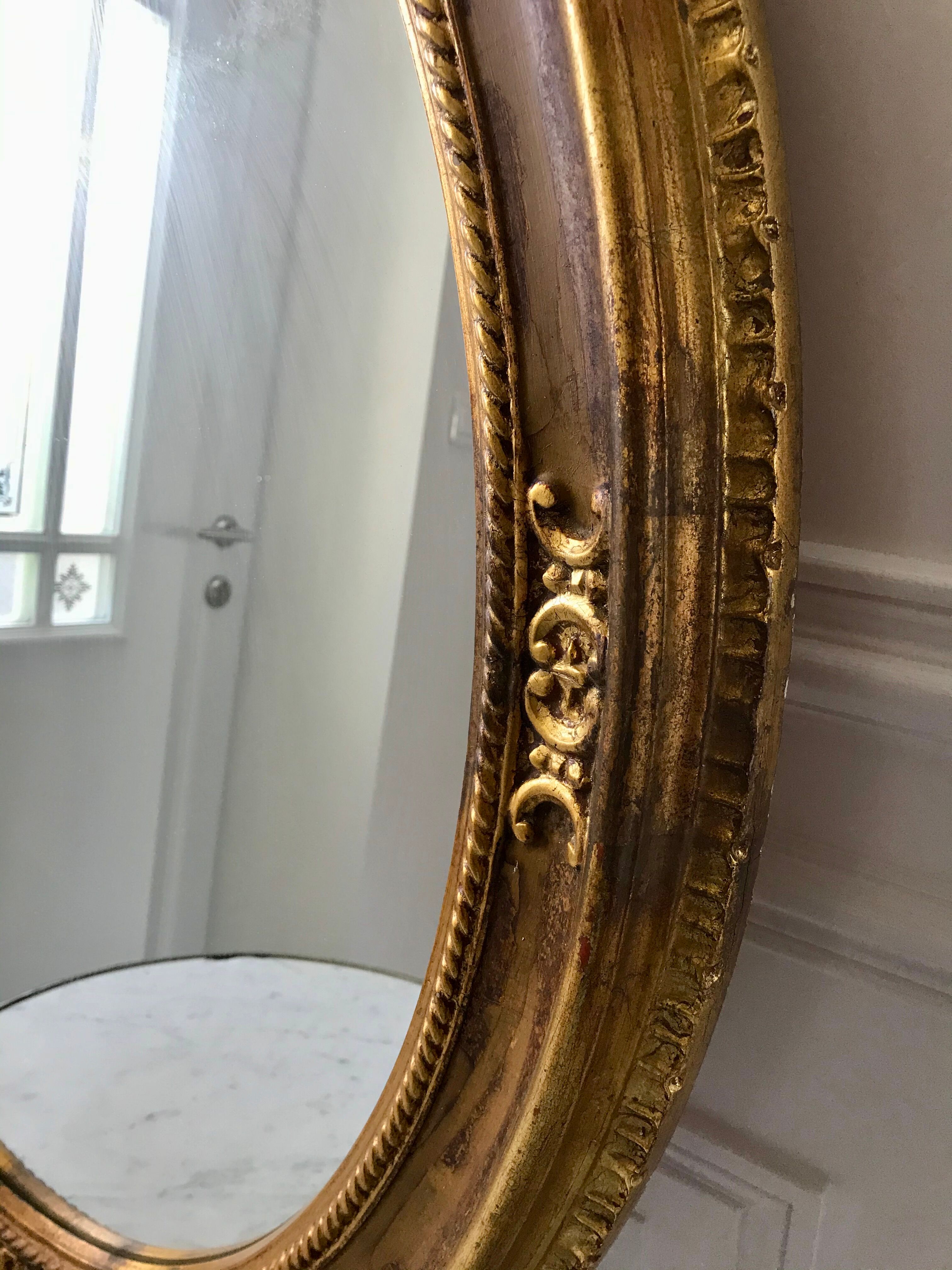 Grand miroir oval en stuc doré vintage