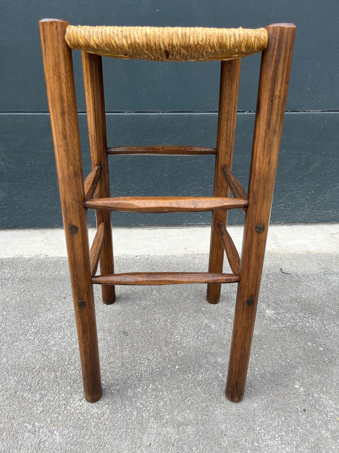 Old high bar stool in wood and straw