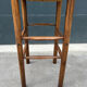 Old high bar stool in wood and straw