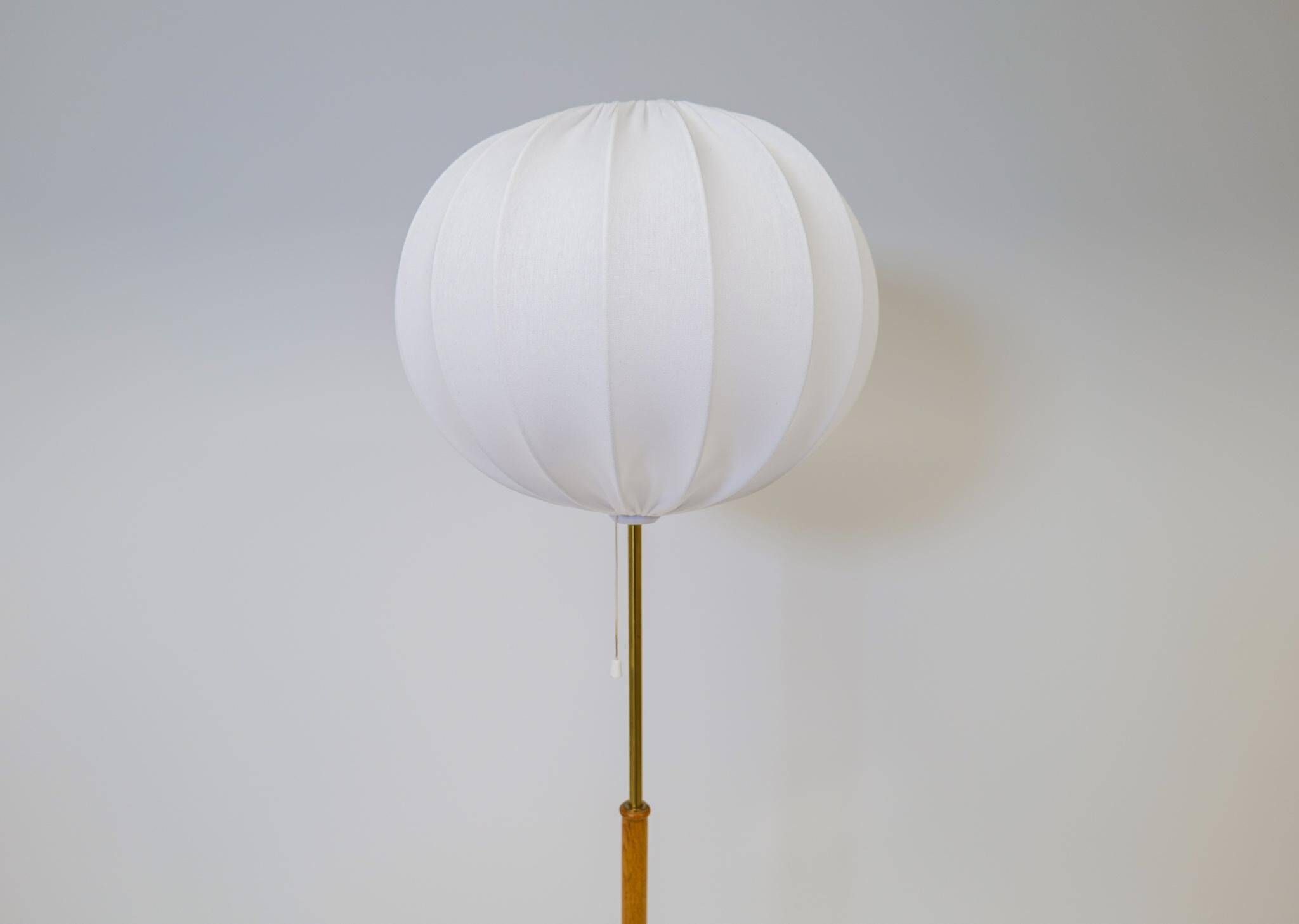 Mid-century floor lamp in brass and oak by Falkenbergs Belysning, Sweden, 1960s.
