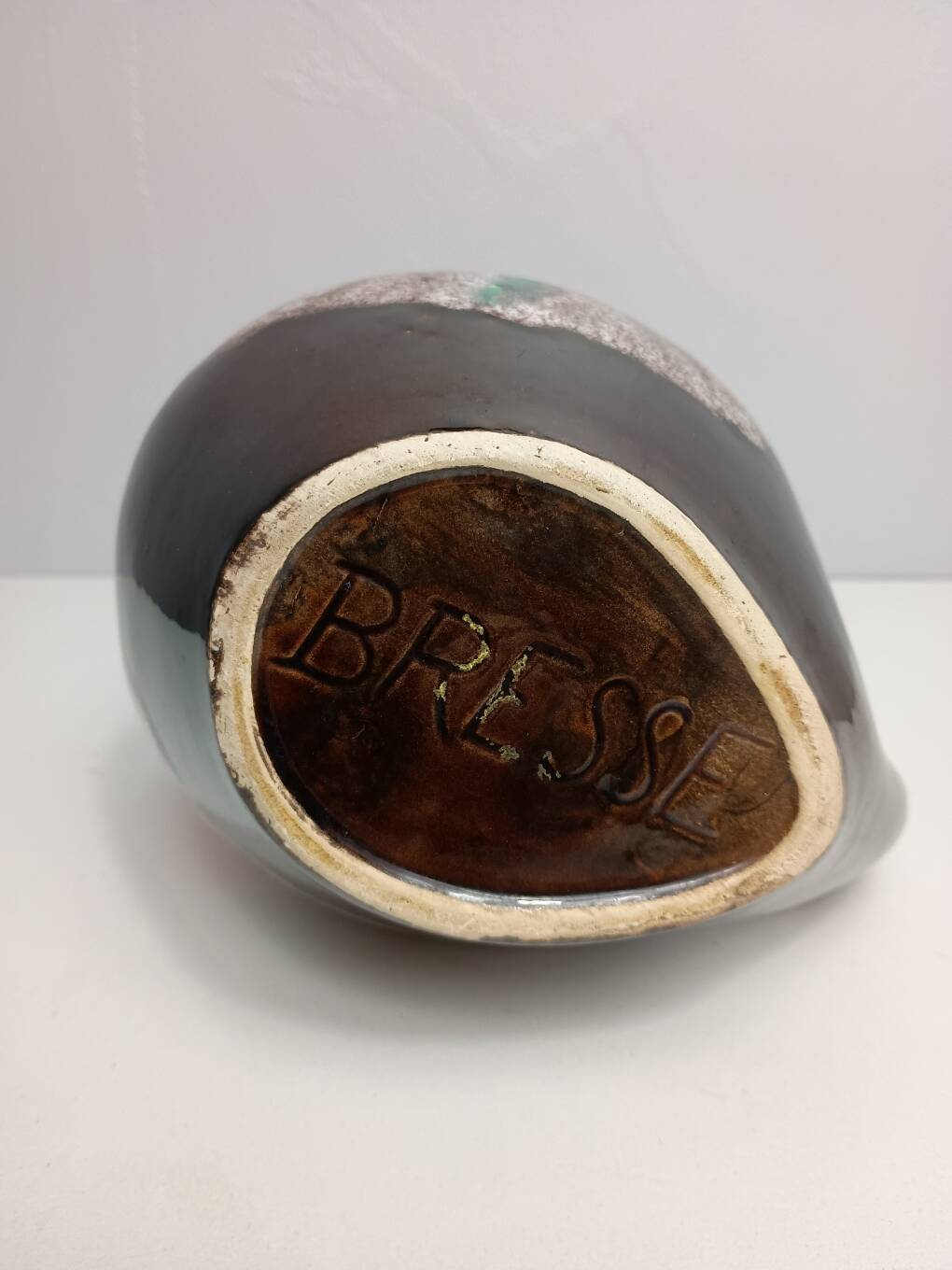 Brown ceramic pitcher with coloured patterns signed Bresse.