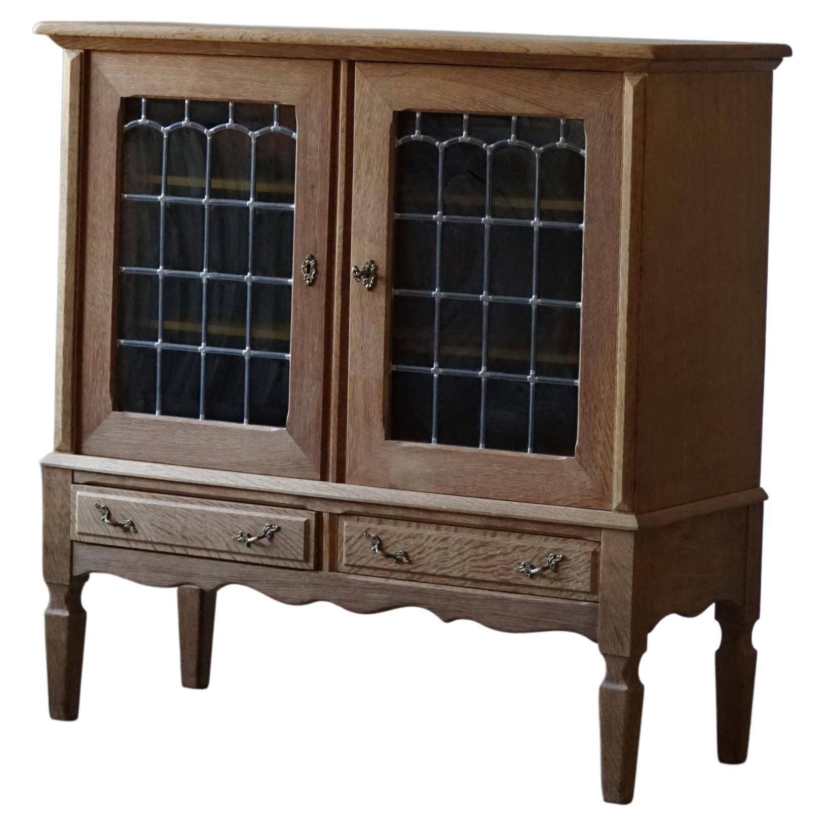 20th-century mid-century solid oak sideboard with glass front, by a Danish cabinetmaker.