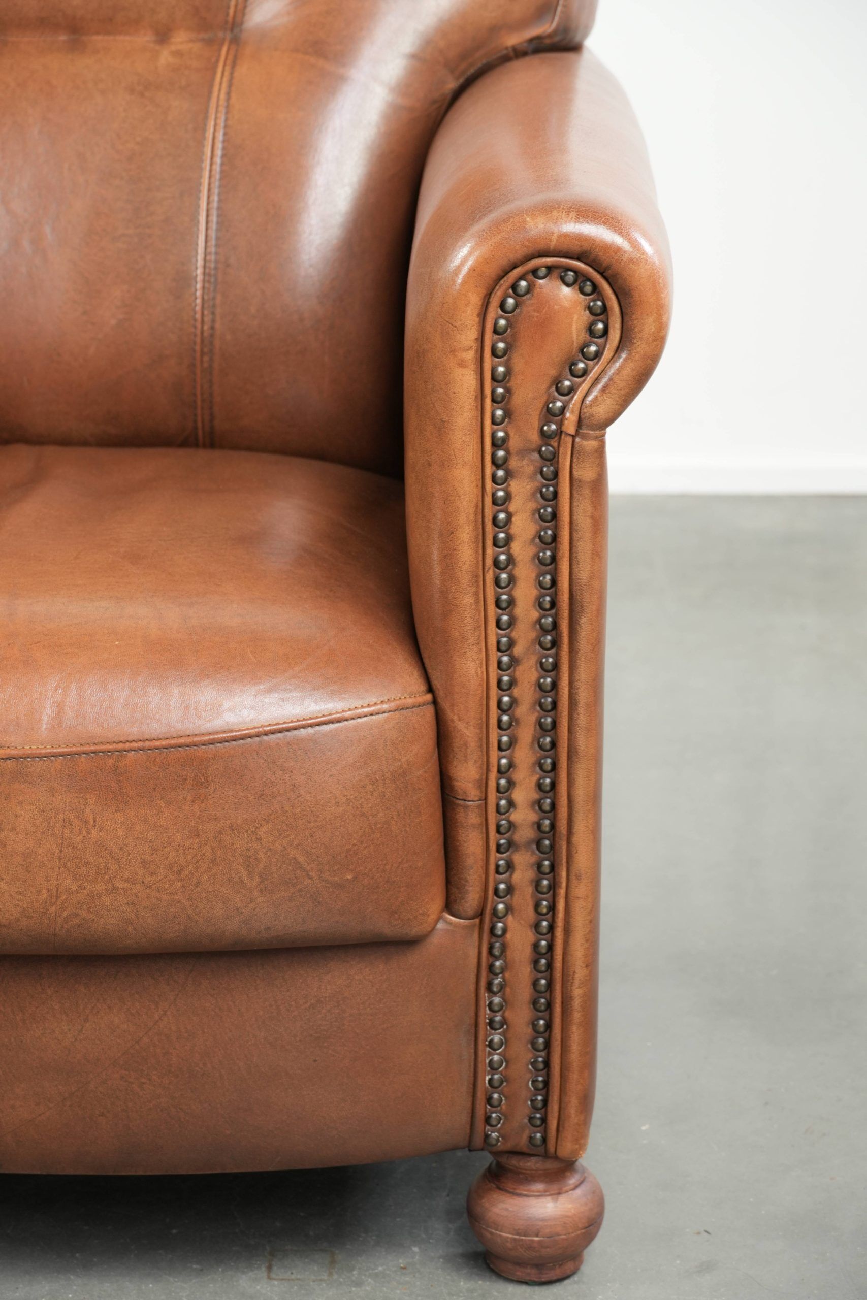 Armchair made of sheepskin leather with refined decorative nail finish
