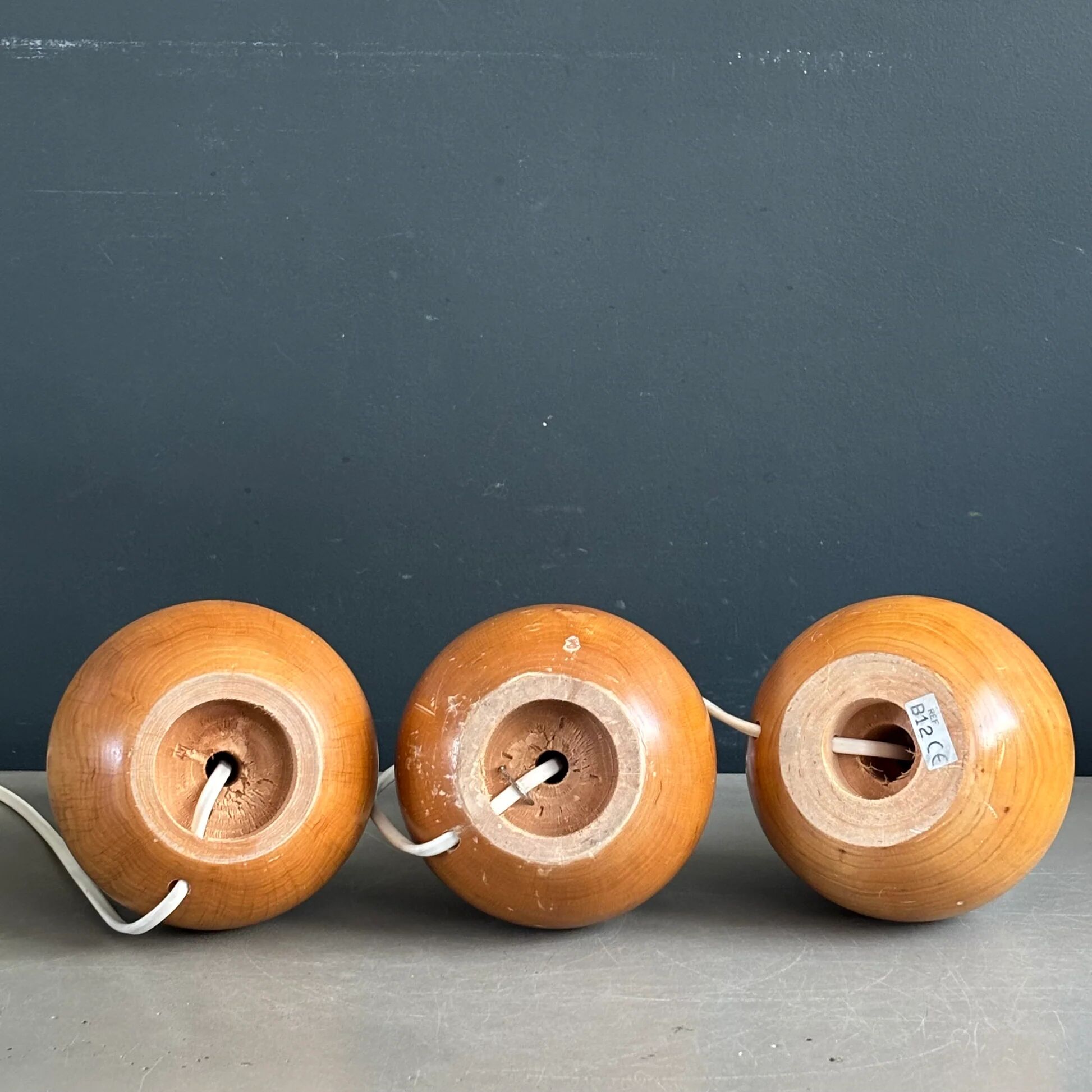 Three wooden ball-shaped lamp stands in light wood.