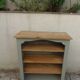 Green-grey library, wooden shelf and shelves in natural wood.