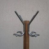 Antique light wood coat rack with splayed legs.