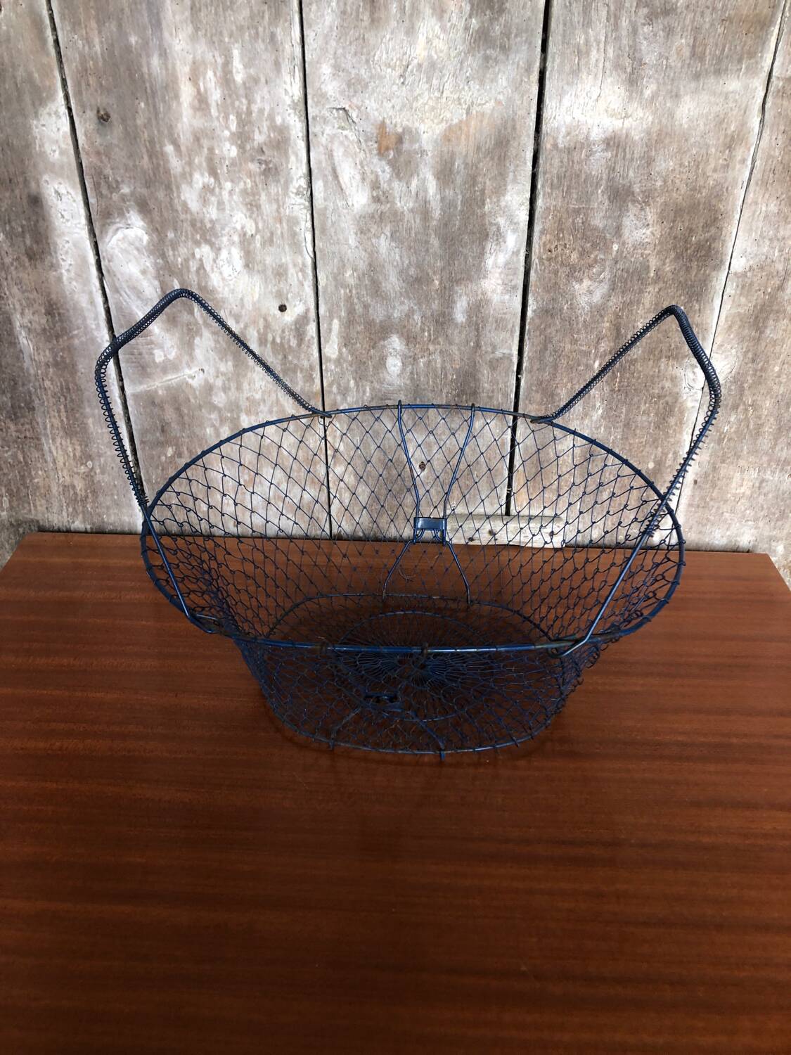Old foldable blue metal basket, vintage handles