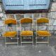 Three folding opera chairs in old gold velvet and brass structure