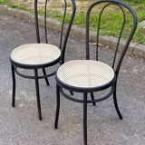 Pair of black steel and plastic cane bistro chairs