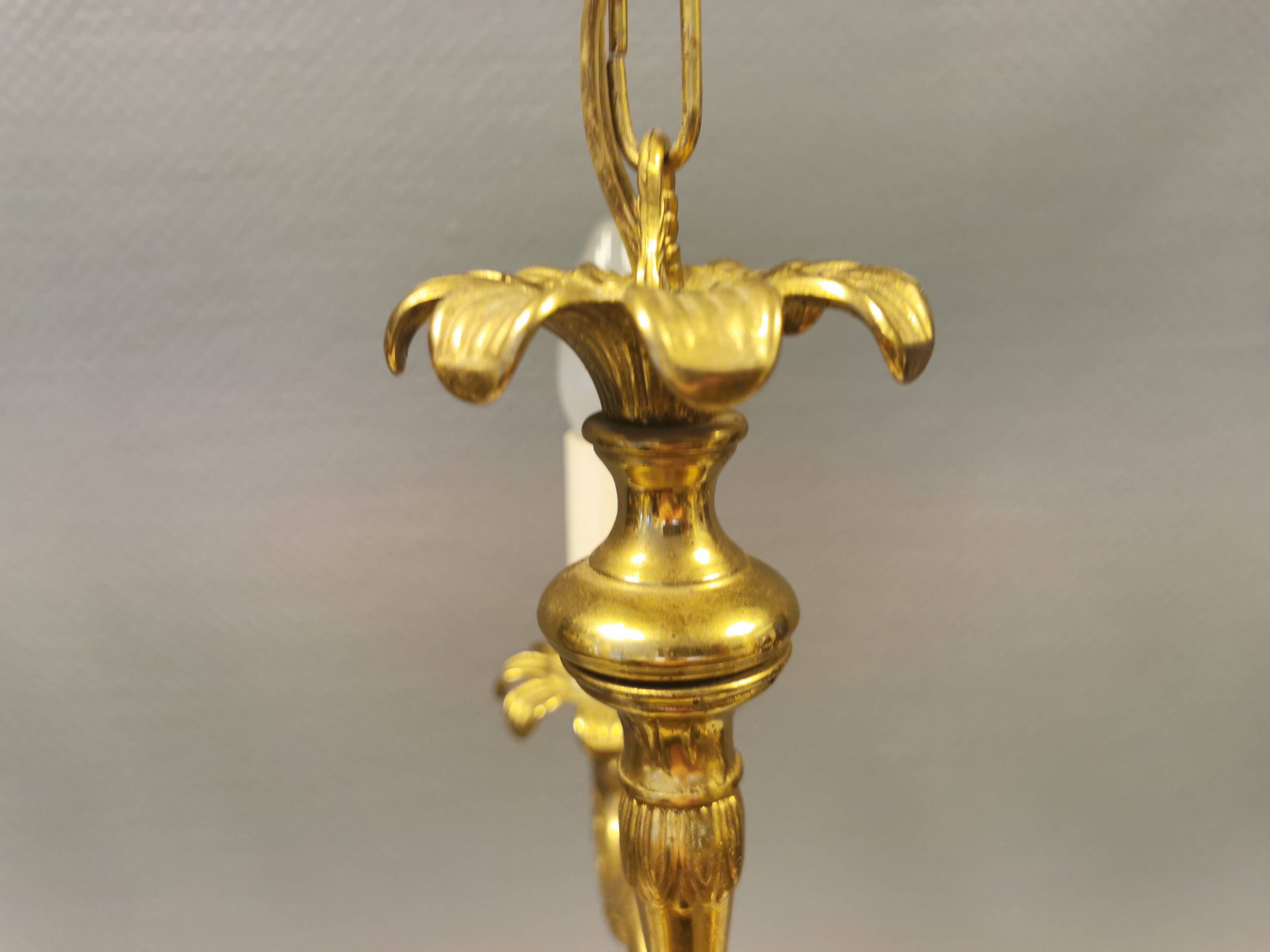 Older brass alloy chandelier with three light sources.
