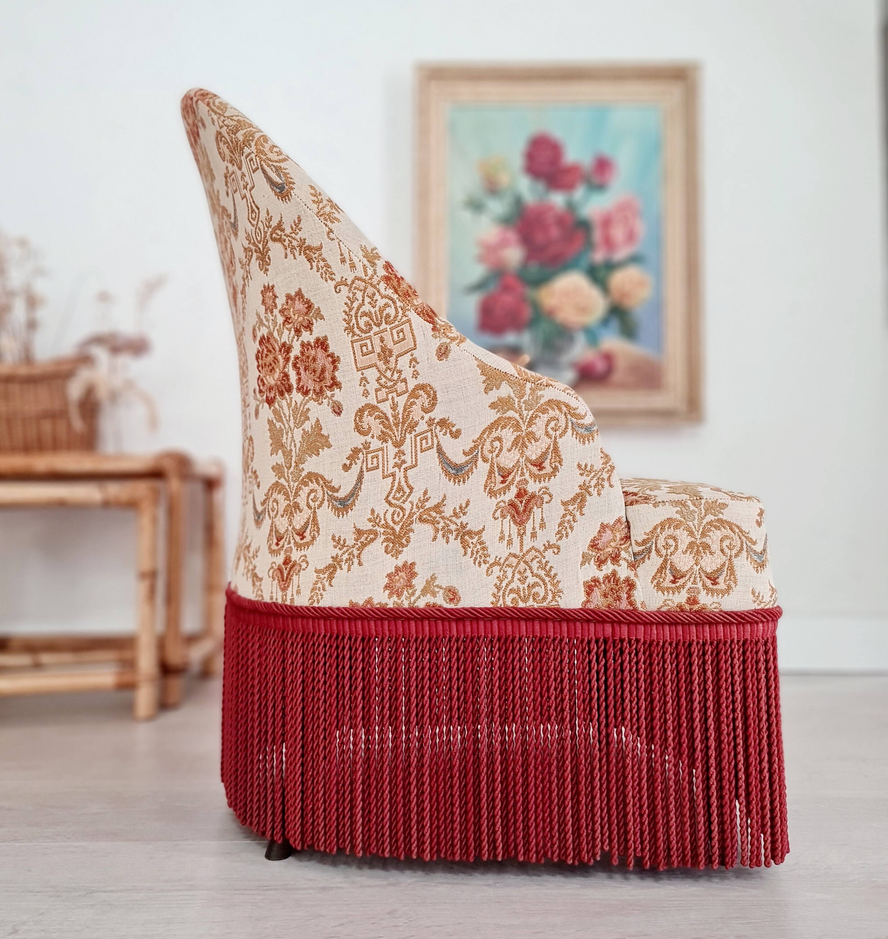 Beige toad armchair with floral patterns and red fringes